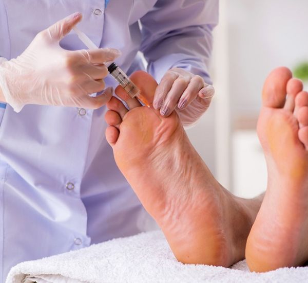 Podiatrist treating feet during procedure